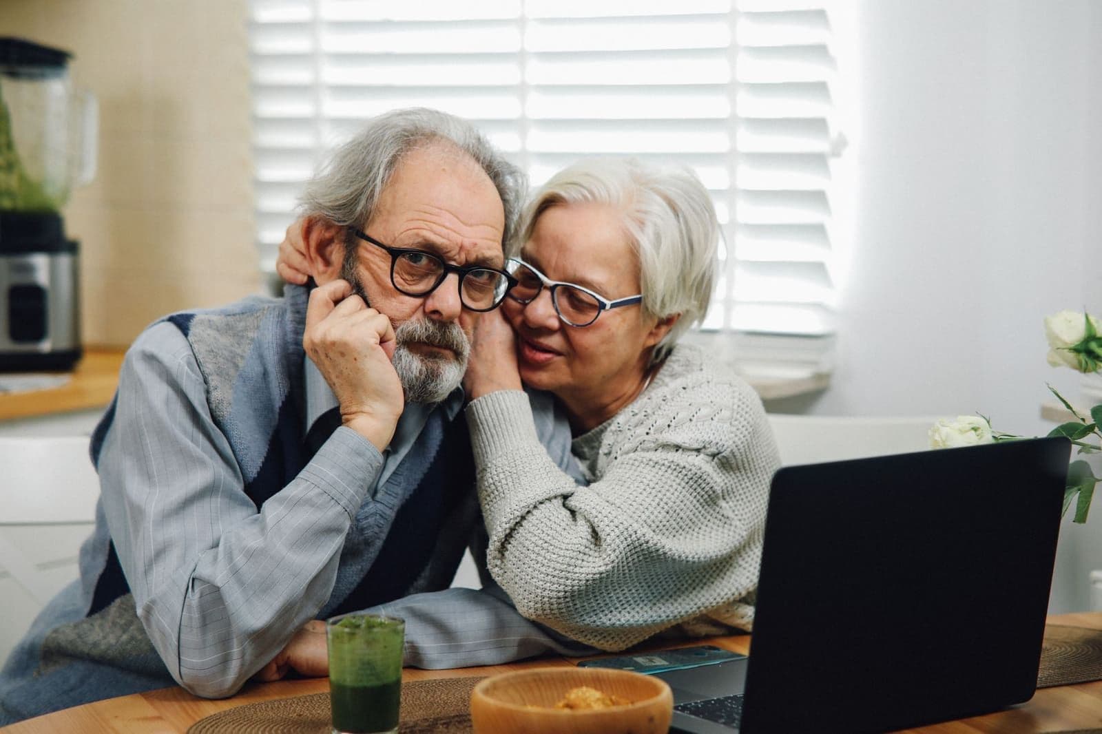 A retired couple comparing AARP life insurance rate letters at their kitchen table