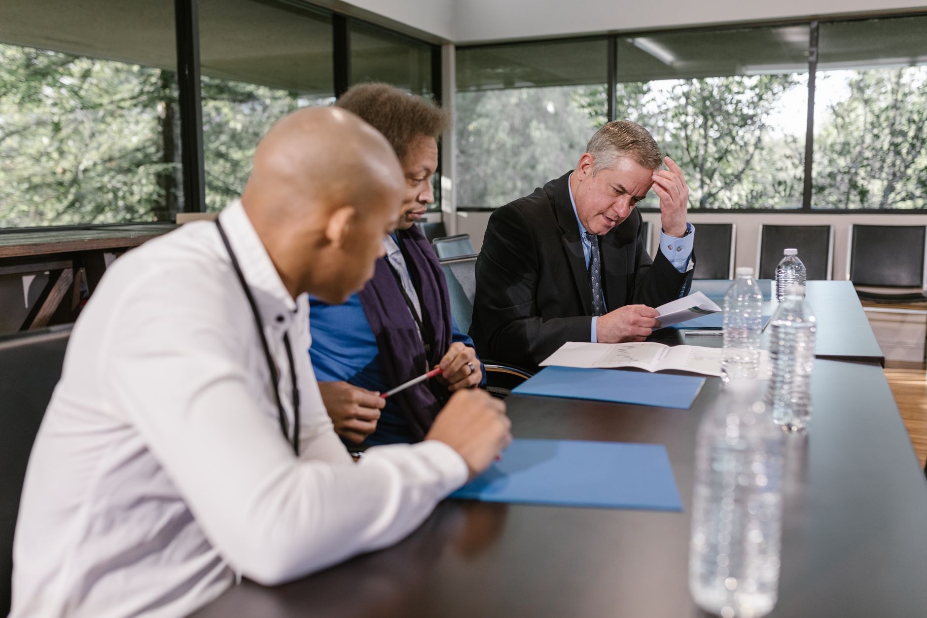 Business owners and a licensed professional reviewing key person and buy-sell life insurance coverage at a conference table